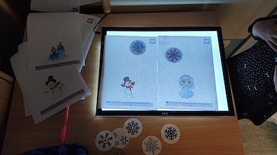 Lesmateriaal Sneeuwvlokken op de lichtbak, met klei en looseparts van auteur juf Vicky derde kleuterklas